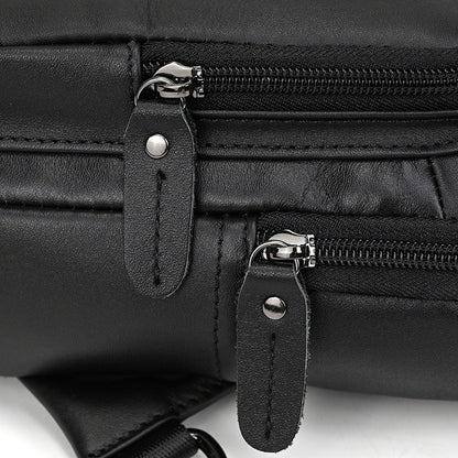 Close-up of a black leather bag with zippers and straps on a white background