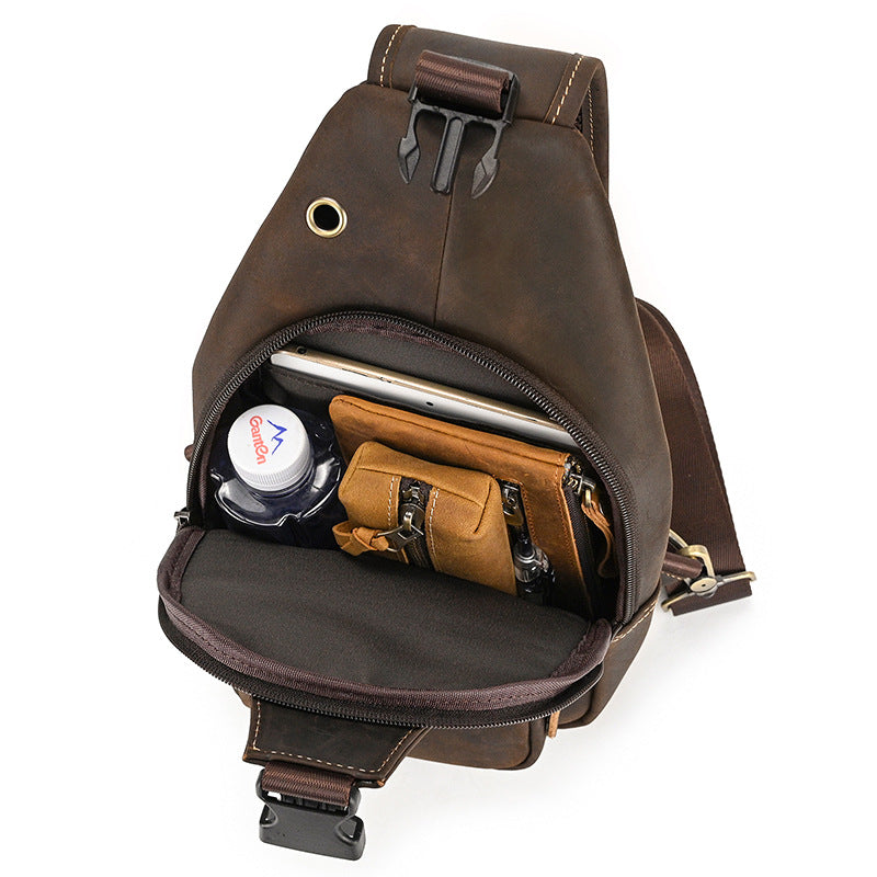 Brown leather sling bag with compartments on a white background