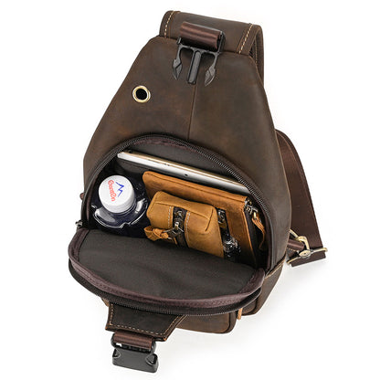 Brown leather sling bag with compartments on a white background