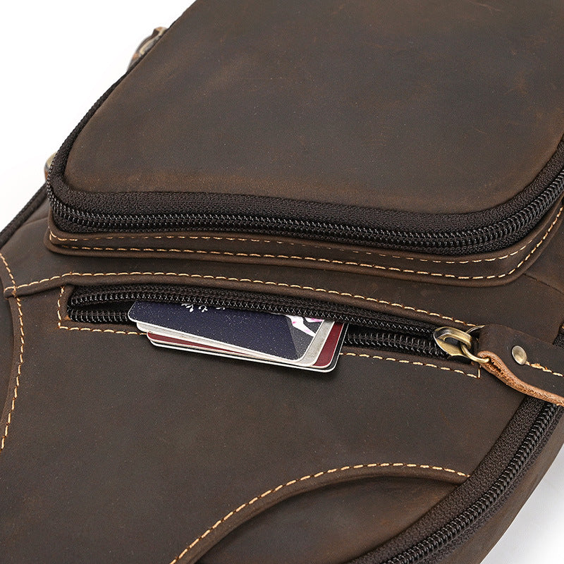 Close-up of a brown leather bag with a zipper pocket on a white background