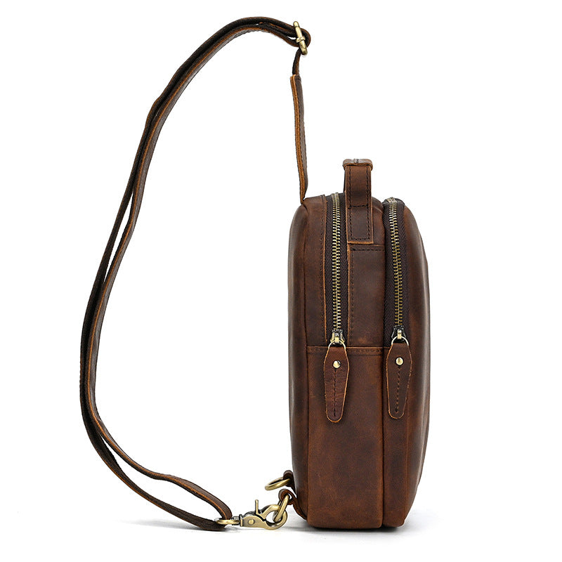 Brown leather crossbody bag with gold zipper on a white background