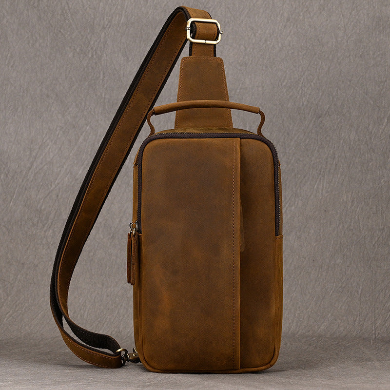 Brown leather sling bag on a gray background