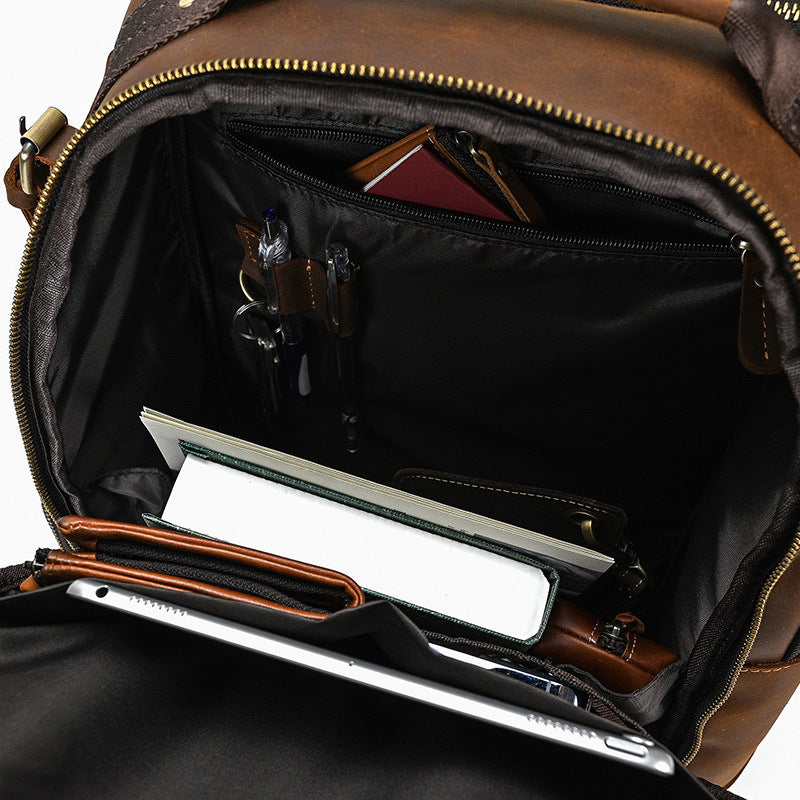 Brown leather backpack with open compartment showing a laptop and items.