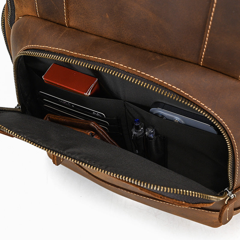 Brown leather backpack with compartments on a white background