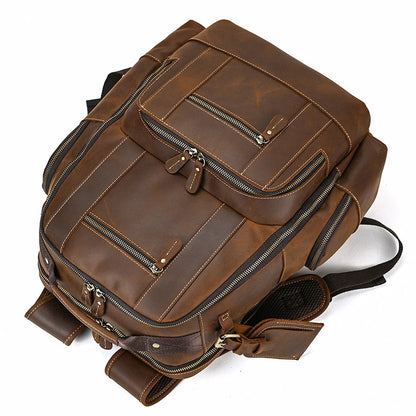 Brown leather backpack with multiple zippers on a white background