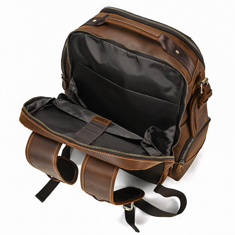 Brown leather backpack with open front compartment on a white background