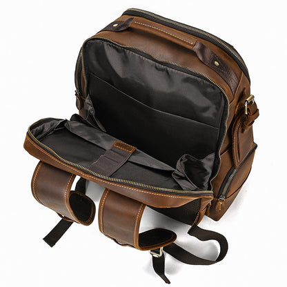 Brown leather backpack with open front compartment on a white background