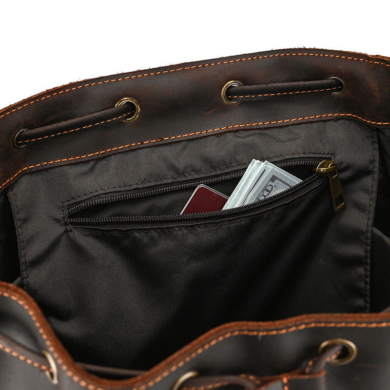 Brown leather bag with a pocket containing money and a card on a white background