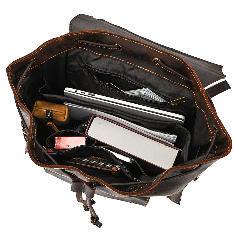 Open leather briefcase with various items inside on a white background