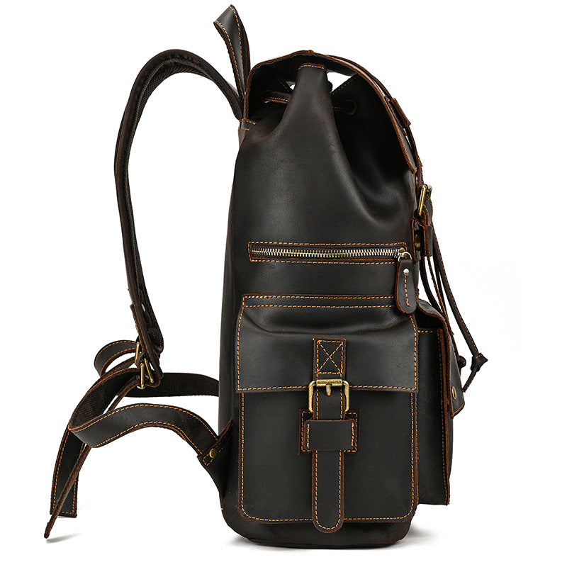 Black leather backpack with gold buckles on a white background