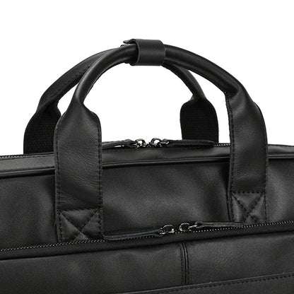 Close-up of a black leather briefcase with handles and zippers.