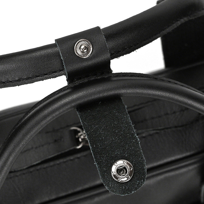 Close-up of black leather straps with metal buckles on a product.
