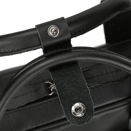 Close-up of black leather straps with metal buckles on a product.
