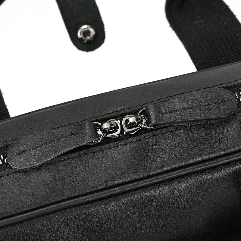 Close-up of a black leather bag with a zipper