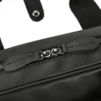 Close-up of a black leather bag with a zipper
