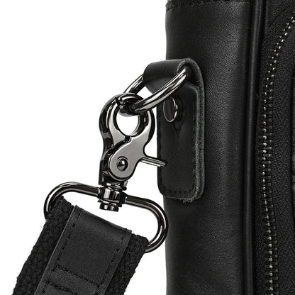 Close-up of a black leather bag with a metal clasp and strap on a white background