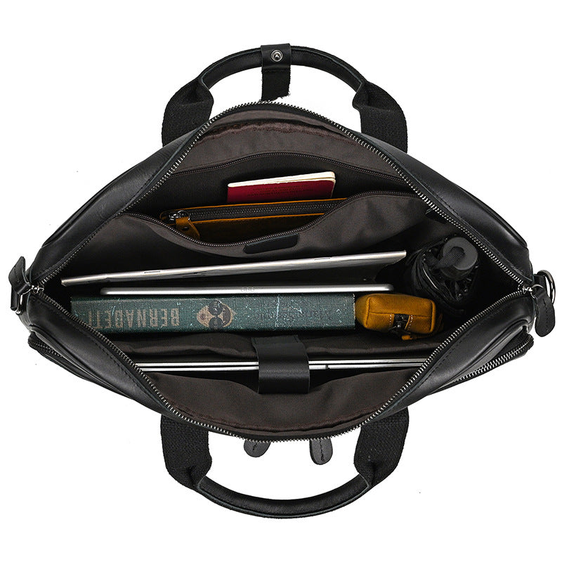 Black backpack with compartments containing a laptop, tablet, and other items on a white background