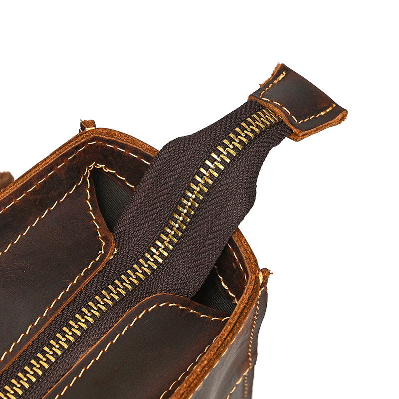Close-up of a brown leather bag with a zipper on a white background