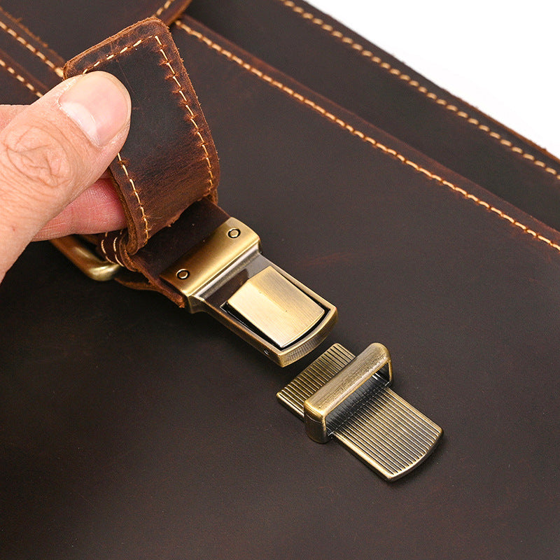 Detailed view of antique brass push-lock clasp and premium dark brown crazy horse leather texture.
