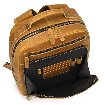 Brown leather backpack with open front pocket on a white background