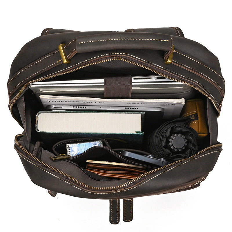 Dark Brown leather backpack with items inside on a white background