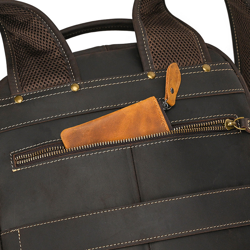 Close-up of a black bag with Dark Brown leather pocket and handle details.