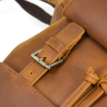 Close-up of a brown leather bag with strap and buckle detail.