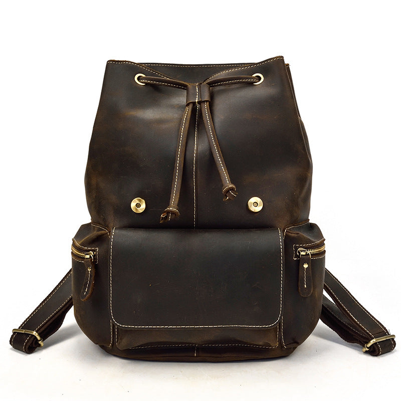 Brown leather backpack with gold accents on a white background
