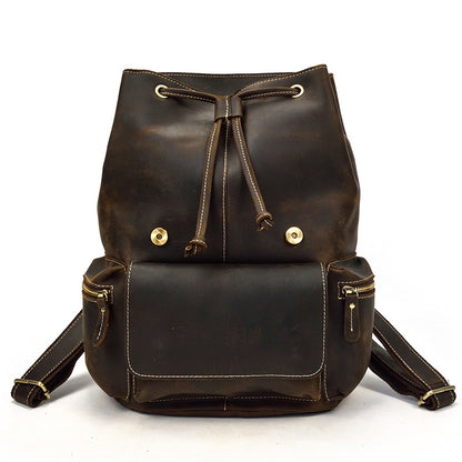 Brown leather backpack with gold accents on a white background