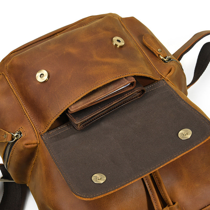Brown leather backpack with visible stitching and metal clasps on a white background