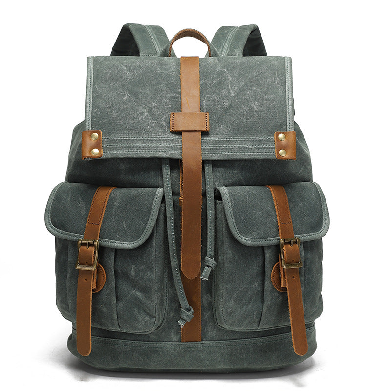 Vintage Waxed Canvas Rucksack Backpack - Front view of the forest green version, featuring durable waxed canvas, two front pockets with brown leather straps, and brass hardware.