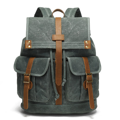 Vintage Waxed Canvas Rucksack Backpack - Front view of the forest green version, featuring durable waxed canvas, two front pockets with brown leather straps, and brass hardware.