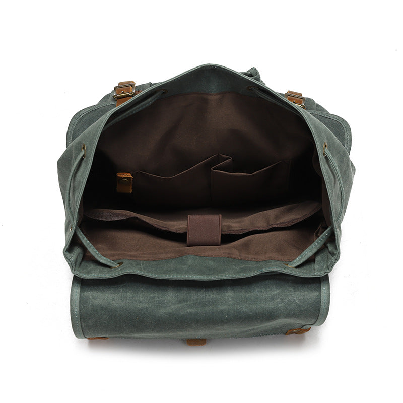 Vintage Waxed Canvas Rucksack Backpack - Interior view of the spacious main compartment, featuring brown lining, multiple organizer pockets, and a dedicated padded laptop sleeve.