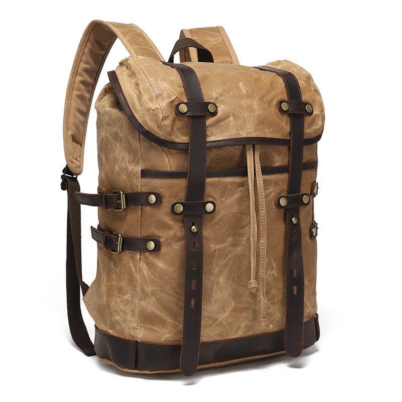 Side-angle view of the vintage waxed canvas backpack showing adjustable leather buckle strap details and side compression straps.