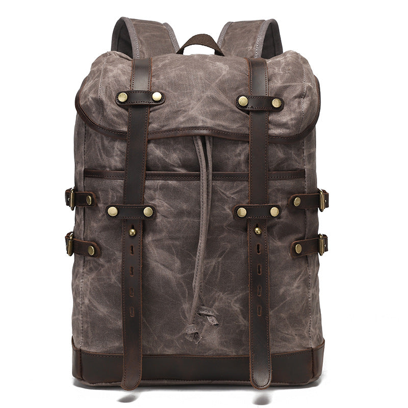 Grey vintage waxed canvas rucksack featuring leather strap detailing and robust water-resistant fabric construction.