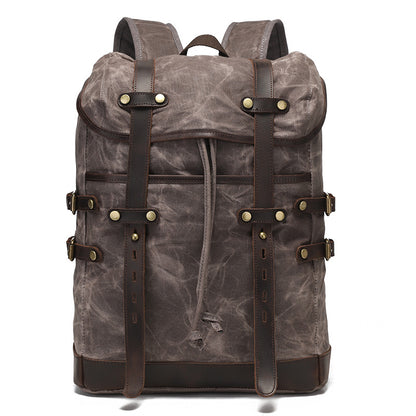 Grey vintage waxed canvas rucksack featuring leather strap detailing and robust water-resistant fabric construction.