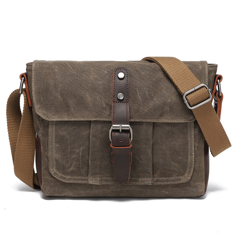 Vintage grey-brown waxed canvas messenger bag with brown leather details, front view.