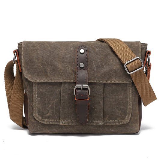 Vintage grey-brown waxed canvas messenger bag with brown leather details, front view.