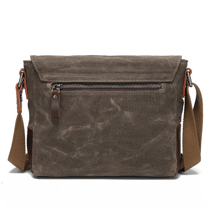 Back view of the grey-brown waxed canvas messenger bag with a durable zippered pocket.