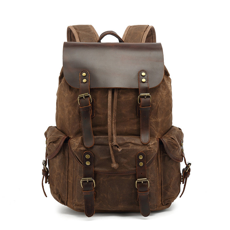Front view of the brown Vintage Waxed Canvas Multi-Pocket Rucksack, showcasing the drawstring closure, leather straps, and brass hardware details.