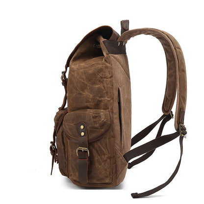 Side profile of the brown Vintage Waxed Canvas Multi-Pocket Rucksack, highlighting the side pocket, padded shoulder strap, and durable canvas construction.