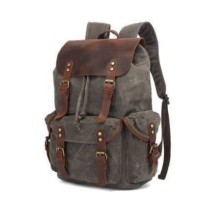 Front view of the charcoal gray Vintage Waxed Canvas Multi-Pocket Rucksack with contrasting brown leather trim and classic buckle closures.